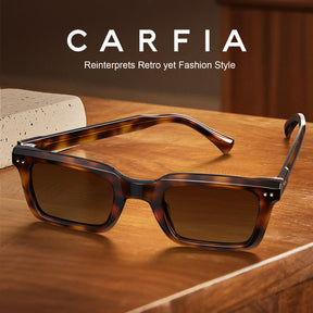CARFIA square-frame sunglasses with a tortoiseshell pattern and dark lenses, resting on a wooden table with a stone block prop. The brand name CARFIA is displayed at the top.